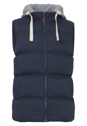 Marineblå puffer vest med aftagelig grå hætte, frontlynlås, tyk polstring, to sidelommer og mærkedetalje på brystet.