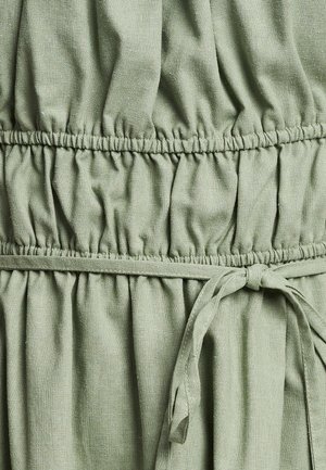 Lichtgroene jurk met verzameld materiaal, een ingezette taille en een strik in de taille. Gemaakt van een gestructureerde, zachte stof.