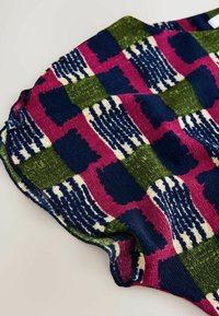 Model de țesătură tricotată în navy, verde, roz și crem; design cu carouri, cu secțiuni texturate și forme de bloc neregulate.