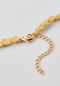 Halskette aus goldfarbenem Metall mit geometrischen Gliedern, strukturierten Oberflächen und einem Karabinerverschluss. Verfügt über eine verstellbare Kettenverlängerung für die Größenanpassung.