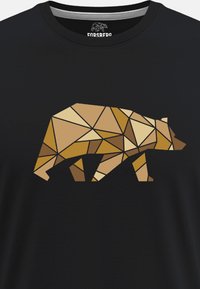 Camiseta negra con un diseño de oso geométrico y poligonal en varios tonos de marrón y beige, que muestra ángulos agudos y formas distintivas.