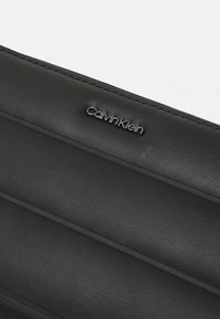 Calvin Klein LINE QUILT LARGE ZIP AROUND - Lompakko - black