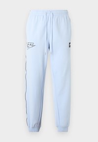 Ανοιχτό μπλε παντελόνι τζόγκινγκ με ελαστική μέση, κορδόνια, μανσέτες στον αστράγαλο, μαύρο λογότυπο Nike Air στο αριστερό μηρό και μαύρο περίγραμμα κατά μήκος του αριστερού ποδιού.