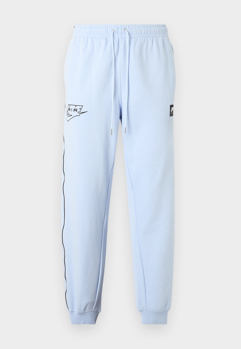 Pantaloni jogger azzurri con fascia elastica in vita, coulisse, polsini alle caviglie, logo Nike Air nero sulla coscia sinistra e piping nero lungo la gamba sinistra.