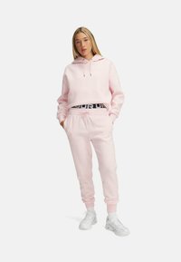 Under Armour RIVAL FLEECE - Pantalon de survêtement - prime pink