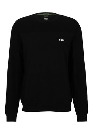 Svart stickad tröja med ribbad textur på axlar och ärmar. Har rund halsringning och en liten vit logotyp på bröstet.