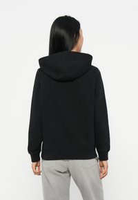 Sweatshirt preto com capuz, de corte descontraído, com punhos e cintura canelada. Tecido macio, sem padrões, visto de trás.