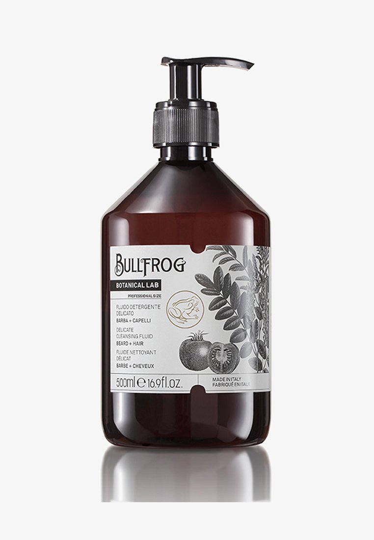 Bottiglia a pompa di un ambra scuro con finitura opaca, dotata di un erogatore argento. L'etichetta frontale include illustrazioni botaniche e dettagli del prodotto in nero.