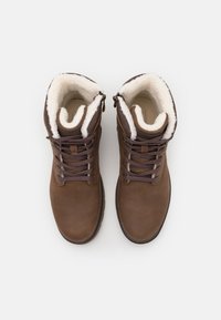 Bruna läderankelboots med fuskpälsfoder, metalöglor och en platt gummisula. Har snörning och en sidoglid för enkel påtagning.
