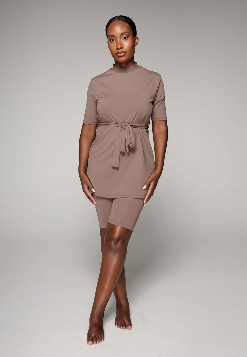 Tenue en tissu brun comprenant un tunique à manches courtes avec une ceinture à la taille et un short de cyclisme assorti, texture lisse et coupe décontractée.