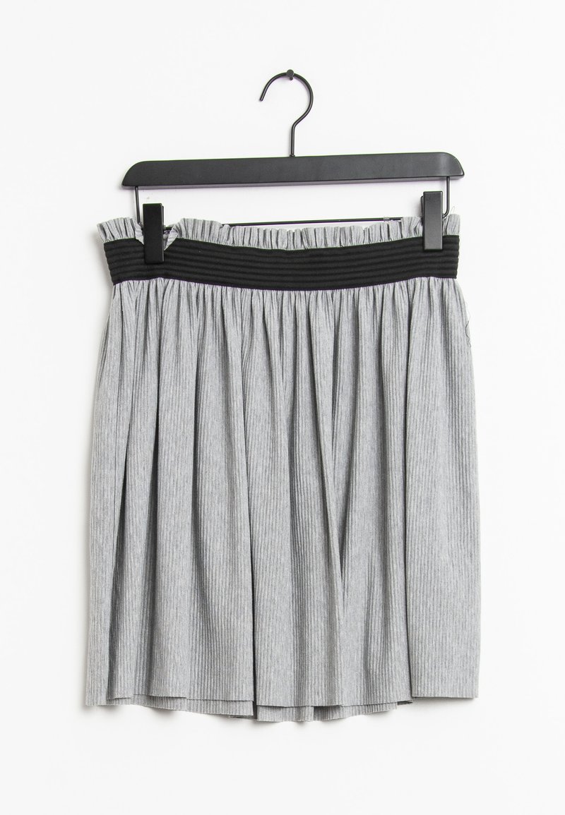 Hame grisifera rayada con una cintura elástica negra, que presenta pliegues y un diseño fruncido. Cuélga de un gancho de plástico negro.