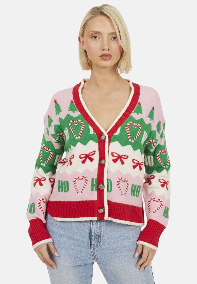 Cardigan en tricot mettant en avant un motif de vacances rose, vert et blanc avec des arbres, des cannes en sucre et des nœuds. Un biais rouge et cinq boutons en bois accentuent l'avant.