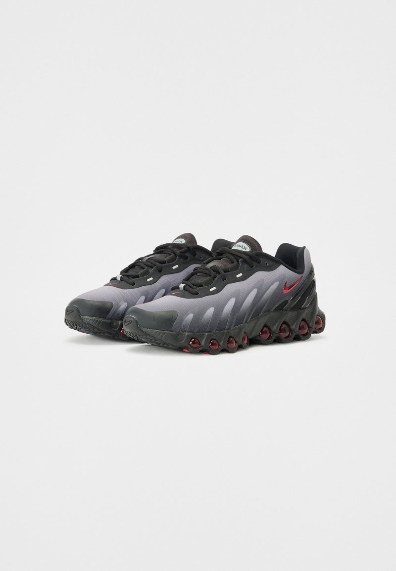 Schwarze und graue Sportschuhe mit einer glatten Oberfläche, strukturierten Akzenten und roten Dämpfungselementen an der Sohle. Verfügt über ein Schnürdesign.