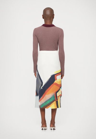 Hosszú fehér szoknya színes absztrakt mintákkal, bordó színű galléros, bordás felsővel párosítva. Az anyag sima, laza viselettel.