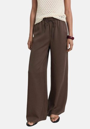 Braune, weit geschnittene Hose aus weichem Stoff, mit einem elastischen Taillenbund und einem Kordelzug zur Anpassung sowie seitlichen Taschen.