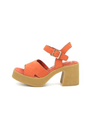 Sandalias de plataforma de ante naranja con puntera abierta, tira en el tobillo y un tacón grueso y texturizado color beige. Presenta un diseño troquelado y hebilla de metal.