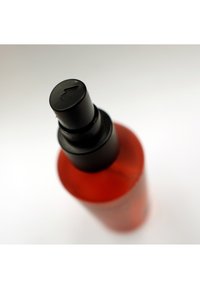 Bottiglia di plastica trasparente con forma cilindrica, tonalità rossa e un tappo a spruzzo nero con un dettaglio a freccia rivolta verso l'alto.