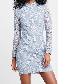 Robe en dentelle bleu clair avec des manches longues, ornée de motifs floraux, d'un col montant et d'une coupe ajustée. Tissu texturé avec des accents transparents.