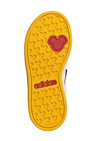 Suola di scarpa Adidas in gomma gialla con un motivo testurizzato di piccole silhouette di Topolino e logo rosso. Design non segnante.