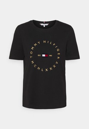 Czarna koszulka z krótkim rękawem ze złotym napisem "Tommy Hilfiger" w okręgu, logo i "EST. 1985" na środku.