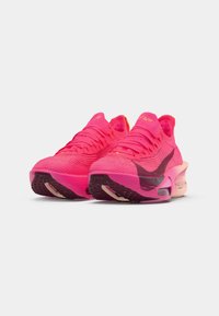 Páros élénk rózsaszín Nike futócipő fekete swoosh logókkal, texturált kötött felsőrésszel és párnázott talppal fehér háttéren.
