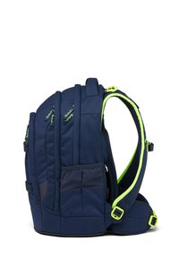 Zaino blu navy con design imbottito, spallacci in rete e accenti verdi brillanti. Presenta tasche laterali e fibbie regolabili per una vestibilità sicura.
