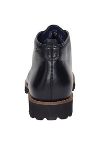 Bottine en cuir noir à bout rond, avec panneau arrière texturé et semelle en caoutchouc robuste. Présente un bord cousu et une languette.