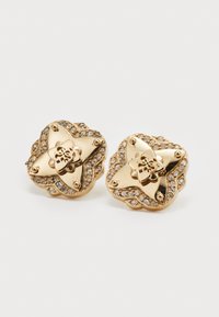 Boucles d'oreilles en doré présentant un design floral, ornées de strass transparents le long des bords et d'un logo en relief au centre.