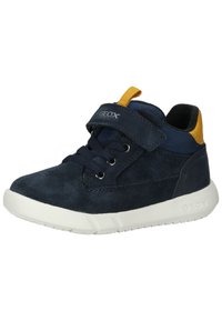Sneaker in camoscio blu navy con suola in gomma bianca, caratterizzato da un accento giallo sul tallone, lacci frontali e cinturino regolabile in velcro.