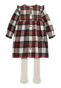 Ruudullinen mekko pitkillä hihoilla, jossa on punaisia, vihreitä ja valkoisia värejä, ryhmitelty yläosa, röyhelökoristelu ja nappiyksityiskohta edessä. Mukana beigekauluksiset sukkahousut.
