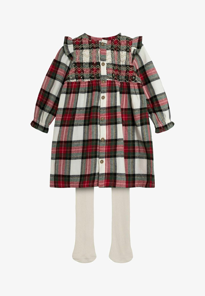 Sukienka w kratę z długimi rękawami, w kolorach czerwonym, zielonym i białym, z marszczonym gorsetem, falbanami i zapięciem na guziki. W komplecie beżowe rajstopy.