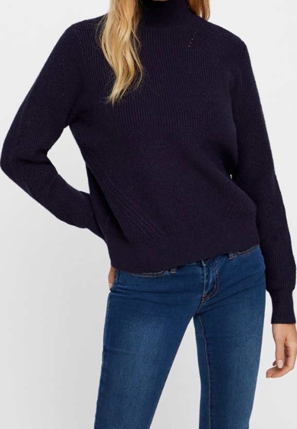 Merensininen neulottu neulepaita korkealla kauluksella, jossa on tekstuuri- ja resoriset hihansuut. Yhdistetty tummansinisiin farkkuihin. Minimalistinen tyyli.