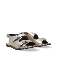 Metallisch zilveren sandalen met open teen, met twee verstelbare gespen. Zwarte zool met een contrasterende gestreepte rand. Gladde textuur.