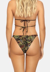 Kostium bikini w wielokolorowym, abstrakcyjnym wzorze w odcieniach zieleni, pomarańczy i czerni. Posiada cienkie czarne ramiączka oraz zawiązywane z tyłu wykończenie.