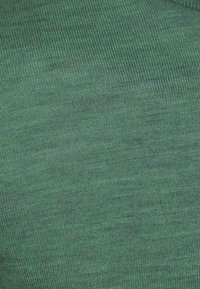 Groene gebreide stof met een fijne ribbelstructuur, die gedetailleerde stiksels en een gelijkmatig weefpatroon laat zien.