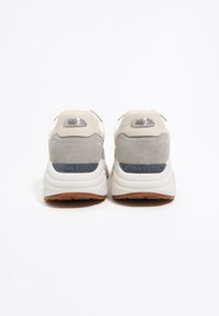 Beżowe i szare sneakersy z zamszu i gładkiej tekstury, z okrągłym noskiem, wyściełanym kołnierzem i teksturowaną gumową podeszwą, z logo z tyłu.