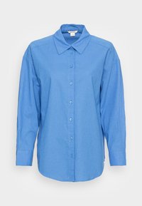 Camicia blu con bottoni, maniche lunghe, colletto e taglio dritto. Presenta una sottile texture e bottoni coordinati lungo la parte frontale.