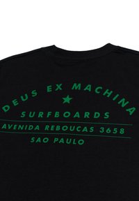 Schwarzes T-Shirt aus Baumwolle mit grüner Schrift. Das Design umfasst "DEUS EX MACHINA SURFBOARDS" und Standortdetails in einem kreisförmigen Layout.