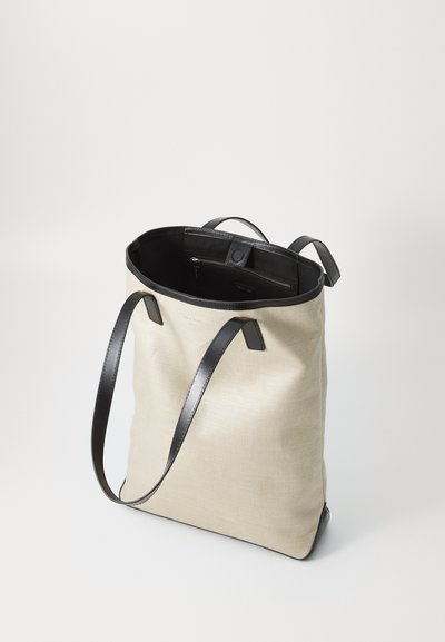 Hellbeige Stofftasche mit schwarzen Ledergriffen und Akzenten. Verfügt über eine innere Reißverschlusstasche und ein schlichtes, zurückhaltendes Design.
