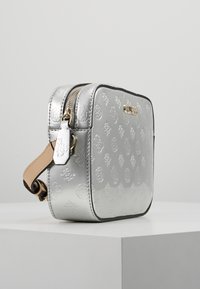 Borsa a tracolla argento in rilievo con forma rettangolare, dotata di doppia cerniera, tracolla in pelle color cuoio e dettaglio logo in tono oro sul davanti.