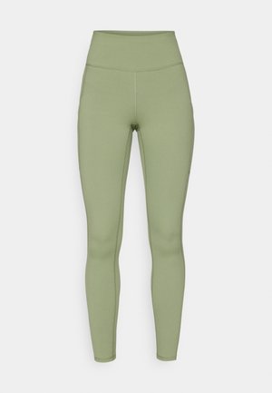 Leggings a vita alta di colore verde oliva. Realizzati in tessuto elasticizzato con una texture liscia, presentano cuciture cucite lungo le gambe.