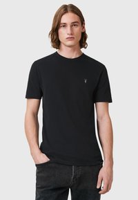 T-shirt nera a maniche corte in cotone, con un classico scollo rotondo e un piccolo logo ricamato sul petto. Texture liscia.