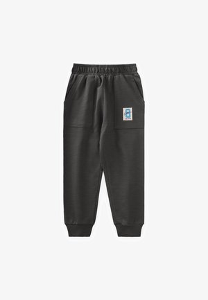 Dunkelgraue Sweatpants aus strukturiertem Stoff, ausgestattet mit einem elastischen Bund, zwei großen seitlichen Taschen und einem kleinen Patch mit einem blauen Design.