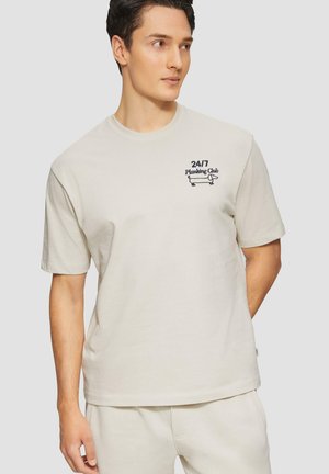 Lichtbeige katoenen t-shirt met korte mouwen, ronde halslijn en geborduurd logo "24/7 Planking Club", voorzien van een eenvoudig, casual ontwerp.