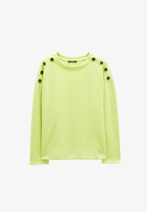 Limonkowa bluza z długim rękawem, okrągłym dekoltem i ozdobnymi brązowymi guzikami na ramieniu. Miękki, teksturowany materiał.