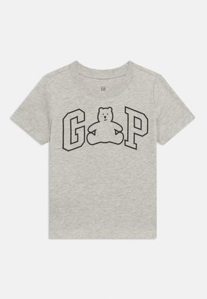 Helehall laste T-särk, millel on ees musta kontuuriga tähed "G" ja "P" ning nende vahel musta värvi teddypõrsapilt.