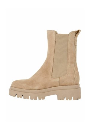 Stivale alla caviglia in suede beige con pannelli laterali elastici, suola a piattaforma spessa e una linguetta sul retro per un facile indossamento.