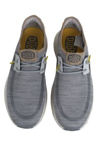 Grijze gebreide schoenen met een gestroomlijnd ontwerp, een tan accent bij de hiel en gele veterslotjes voor een veilige pasvorm. Licht gespikkelde zool.