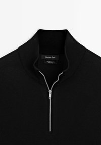 Black merino wool pullover with a high collar and silver zipper. Features a smooth texture and minimalistic design, no patterns or accents.