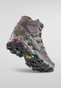 Högpresterande vandringskänga i mörkgrått med lila och turkosa accenter. Har en texturerad överdel, robust sula och ett snabbt snörningssystem.